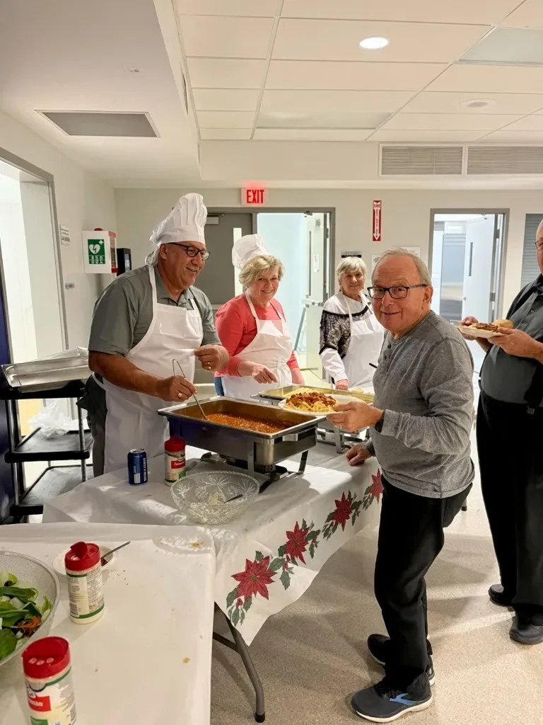 Rick Champagne at a community dinner in East Ferris, with volunteers serving food